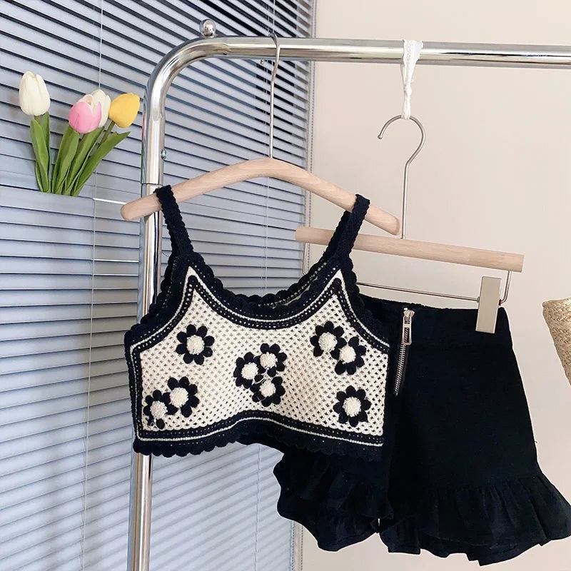 Fashion Baby Girl Knitted Set Strap Flower Vest and Shorts 2PCS Summer Suit in black and white hanging on wooden hangers