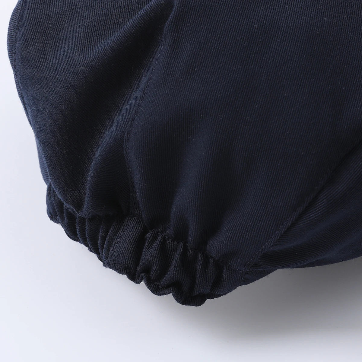 Close-up of the elastic cuff detail on a navy blue baby outfit, showcasing the fabric texture and fit.