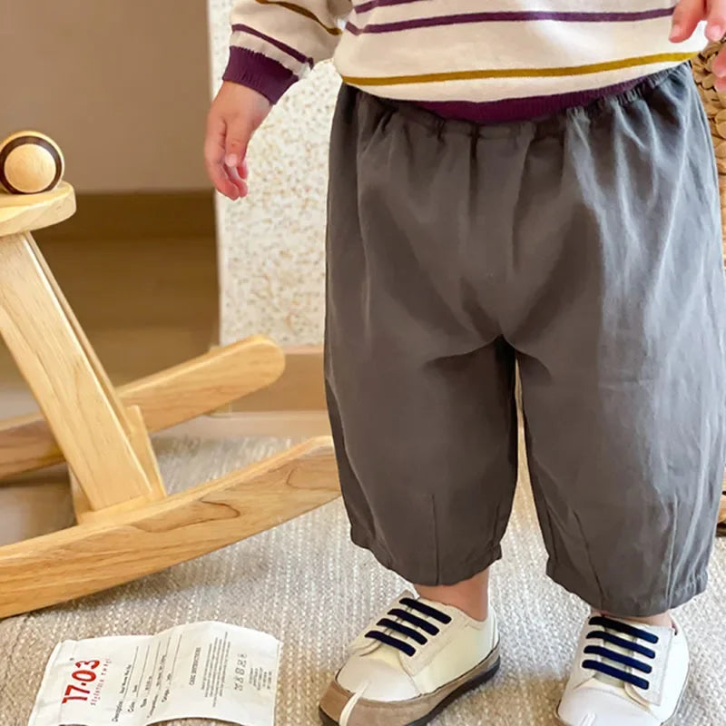 Solid Kids Fashion Trousers Casual Loose Pocket Ankle Length Pant for Boys Girls in gray worn by child standing indoors