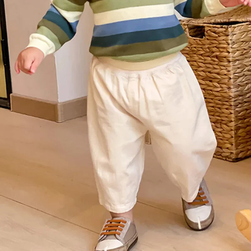 Solid Kids Fashion Trousers Casual Loose Pocket Ankle Length Pant for Boys Girls in cream color worn by toddler