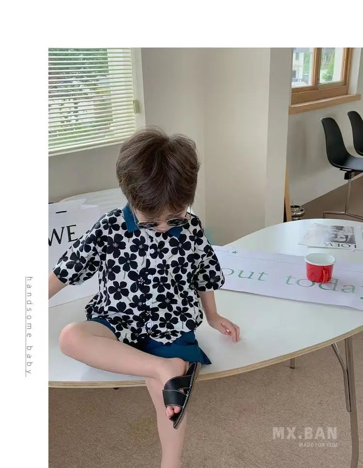 Stylish Flower Suit for Children Baby Short Sleeve Shirt and Casual Shorts Set worn by a toddler sitting on a white table indoors