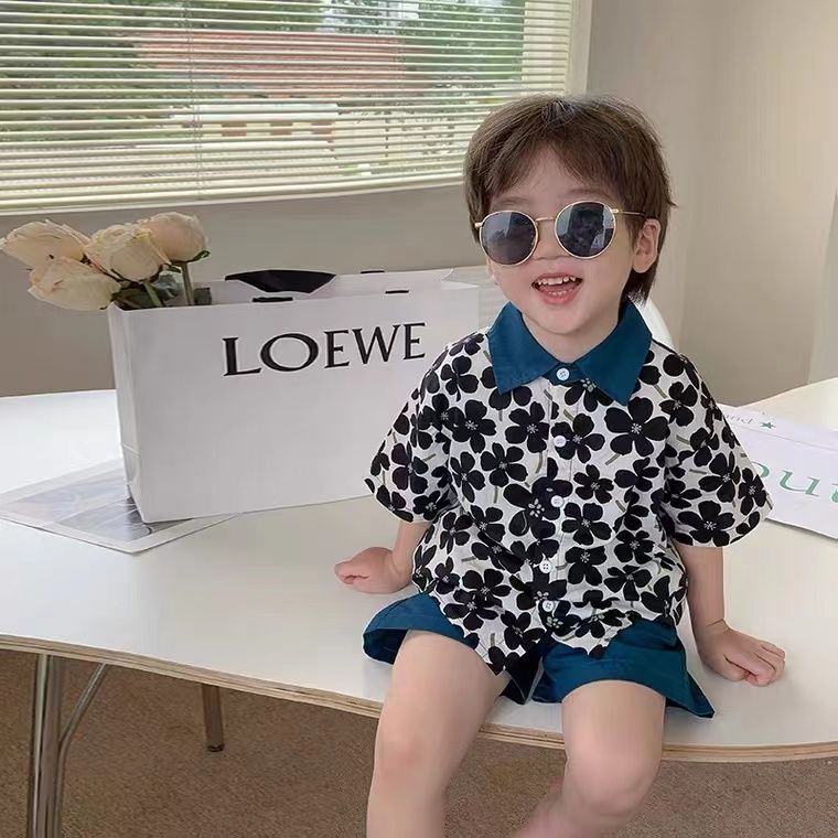 Child wearing Stylish Flower Suit for Children Baby Short Sleeve Shirt and Casual Shorts Set sitting on table with sunglasses