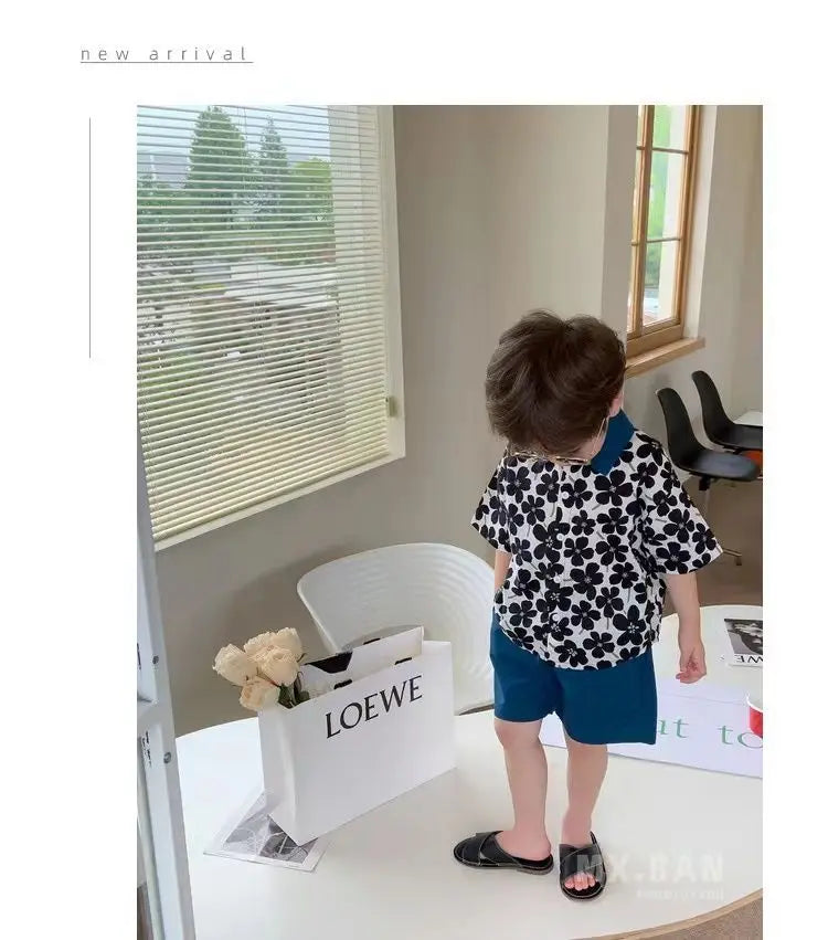 Child wearing Stylish Flower Suit for Children Baby Short Sleeve Shirt and Casual Shorts Set in black and blue indoors