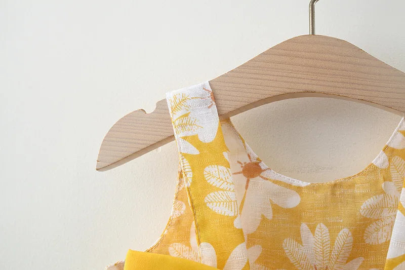 Toddler girl clothes cotton beach dress with yellow and white floral pattern on wooden hanger