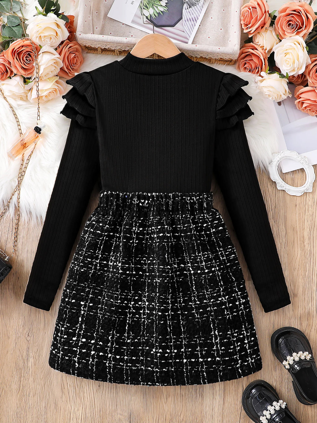 Kids Fashion Fall Set 2 Piece Black High Neck Petal Sleeve Top and A-line Skirt laid flat with black shoes and floral decor