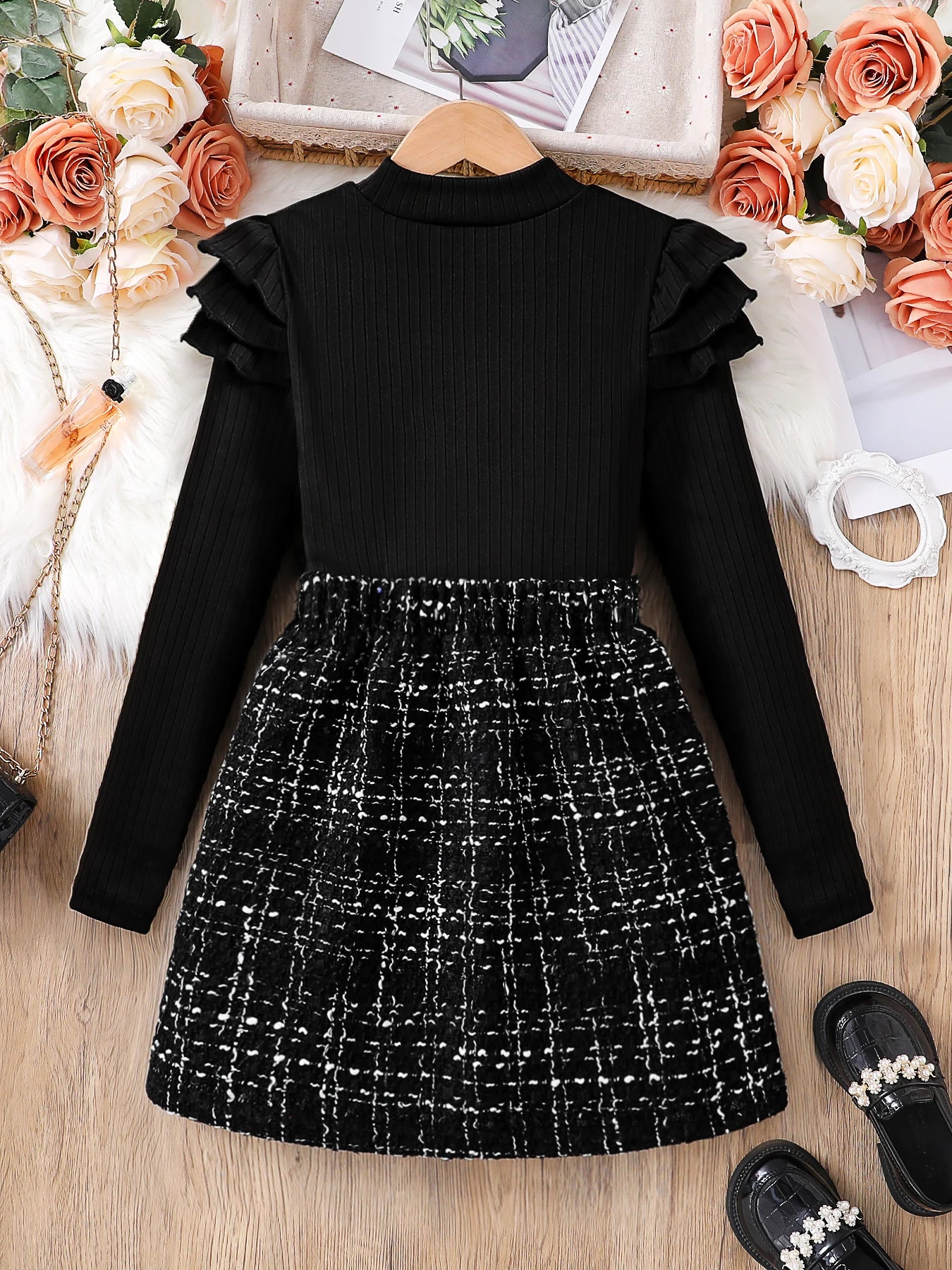 Kids Fashion Fall Set 2 Piece Black High Neck Petal Sleeve Top and A-line Skirt laid flat with black shoes and floral decor