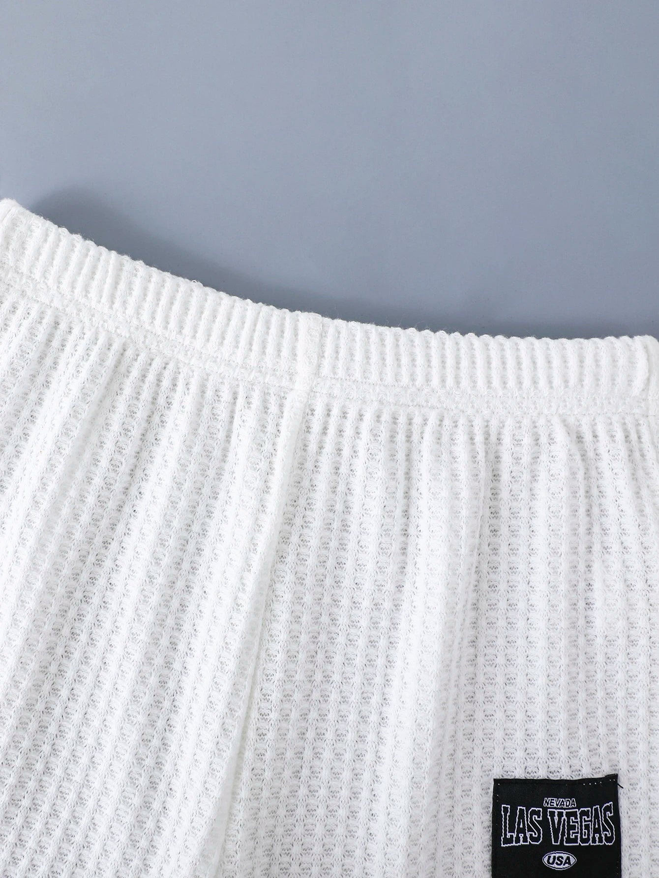 Close-up of white waffle knit shorts part of Stylish Boys Outfit Set Trendy Short Sleeve Shirt and Shorts Summer Design